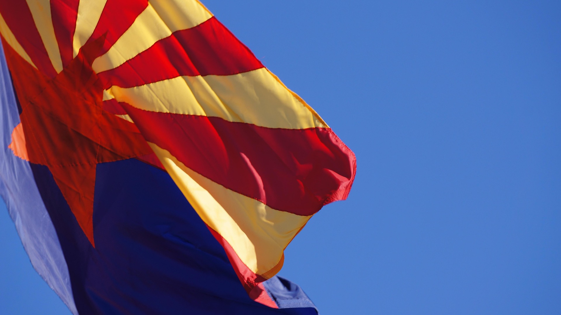 Arizona US flag waving under blue skies