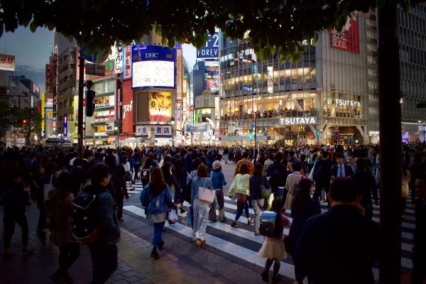Japanese city many people walking through busy intersection at night