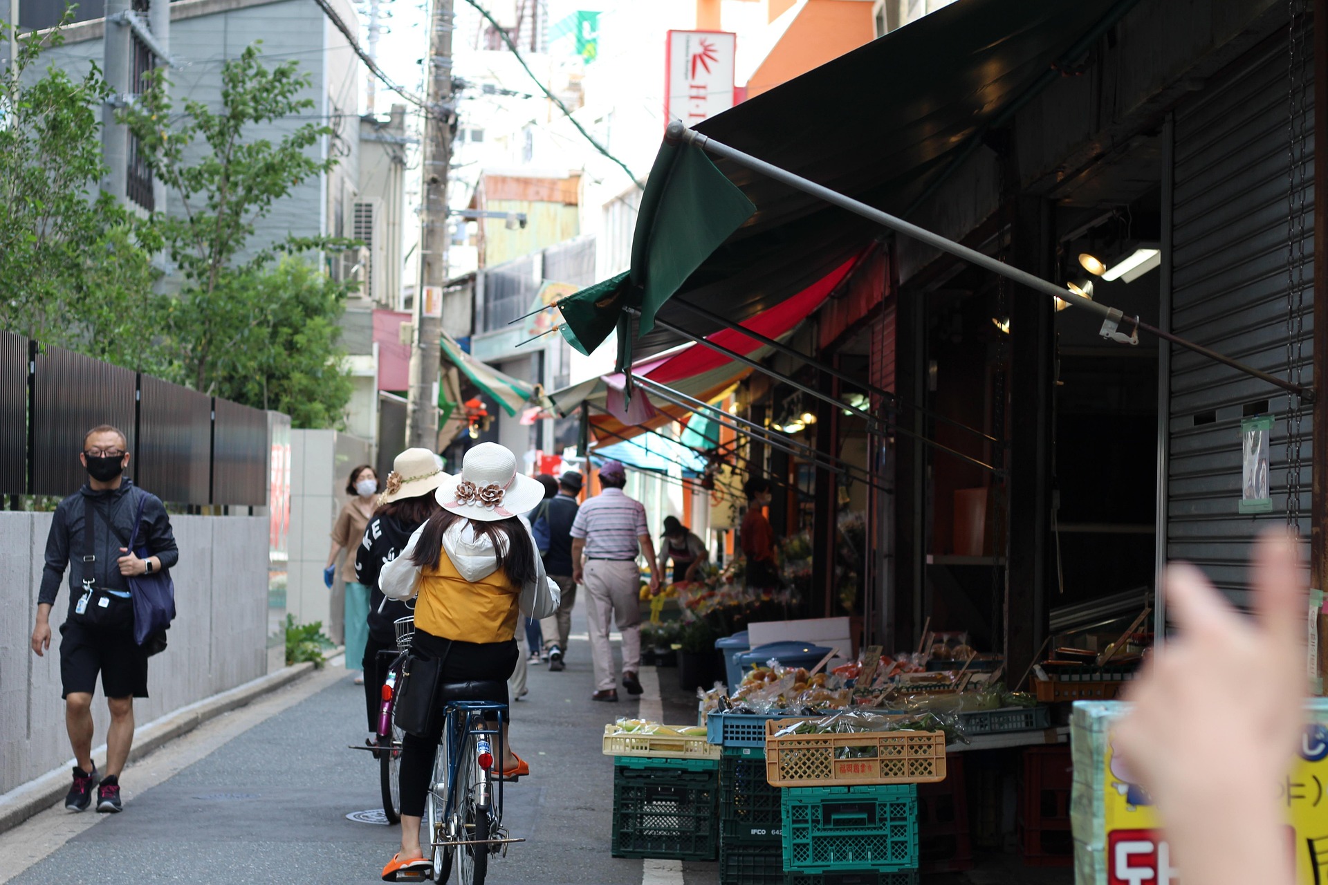 Japanese shopping street-during daytime, women on bicycles