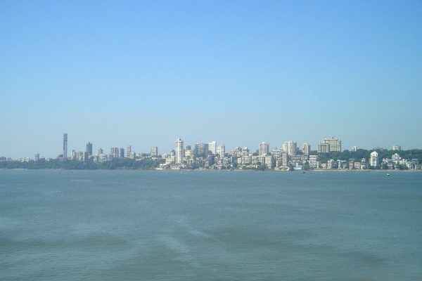 Mumbai India skyline in distance behind body of water
