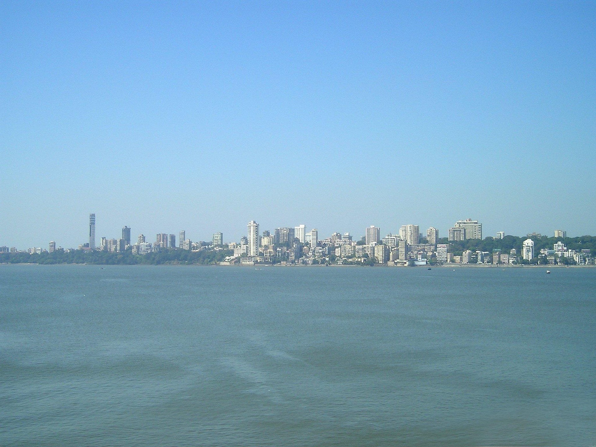 Mumbai India skyline in distance behind body of water