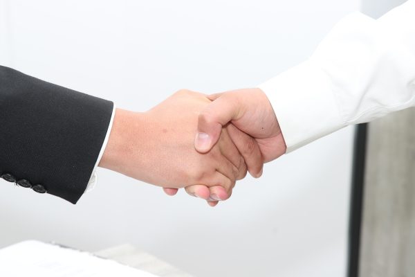 handshake white suit and dark suit