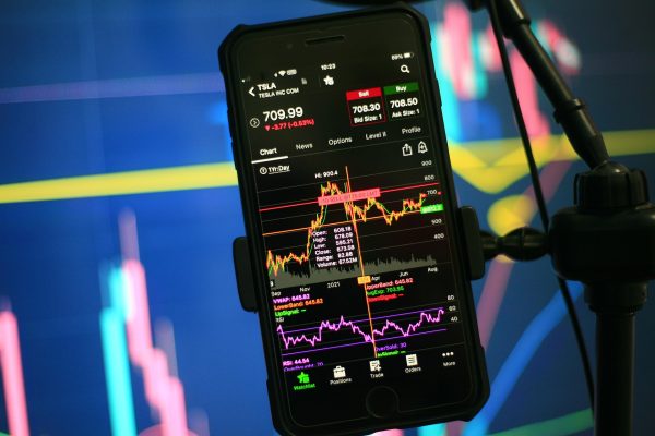 phone showing stock tracking app held by phone holder
