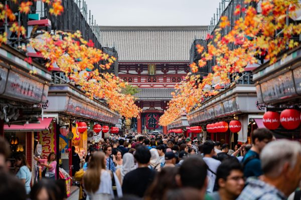 senso-Japan daytime market many people with orange leaves above stores