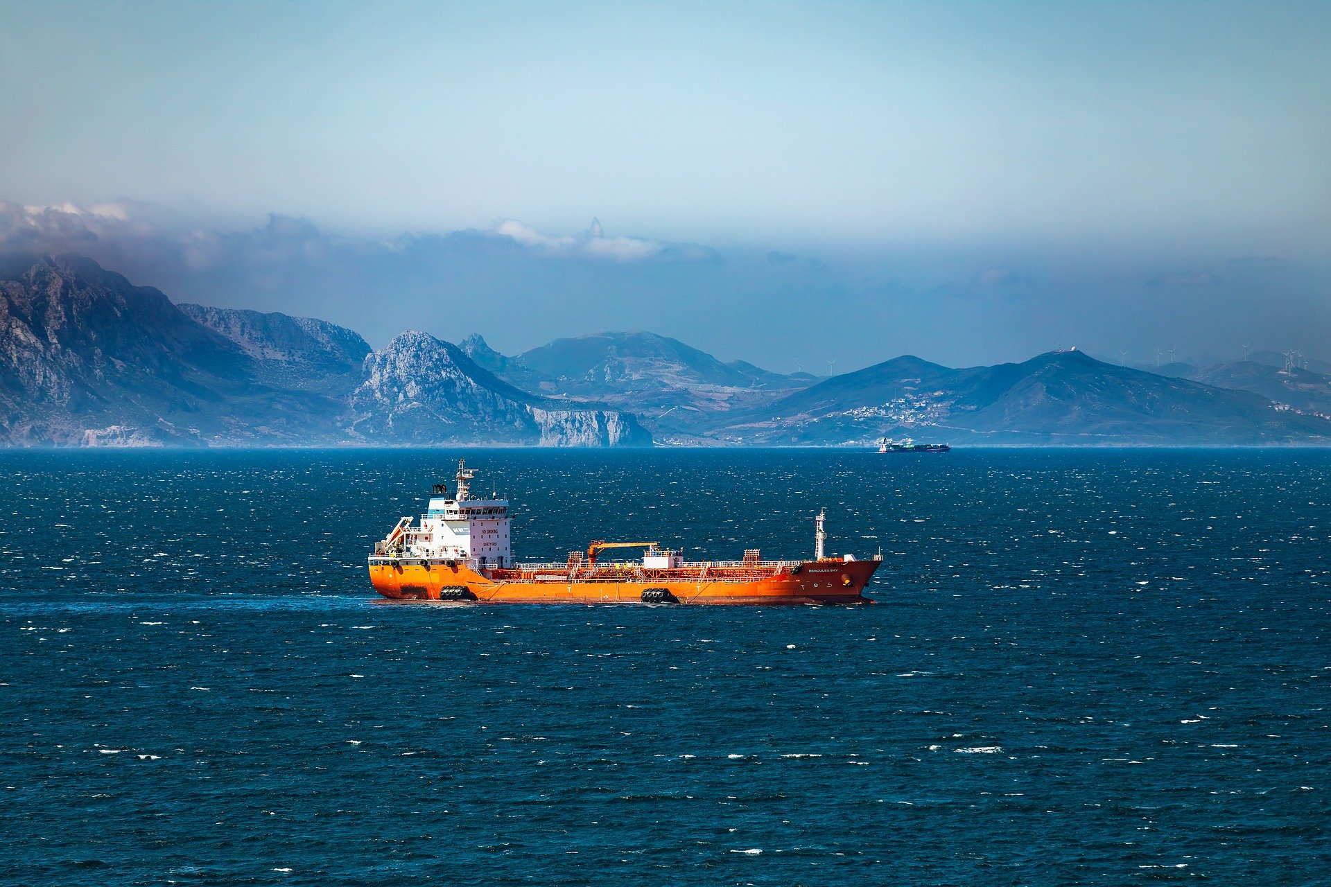 tanker ship in the sea mountains in distance