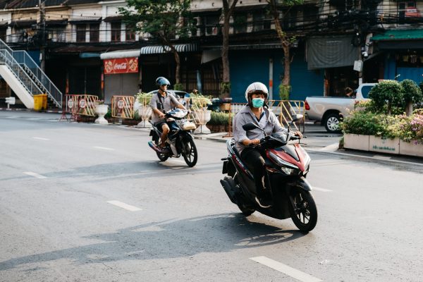two men riding mopeds down Chinese road