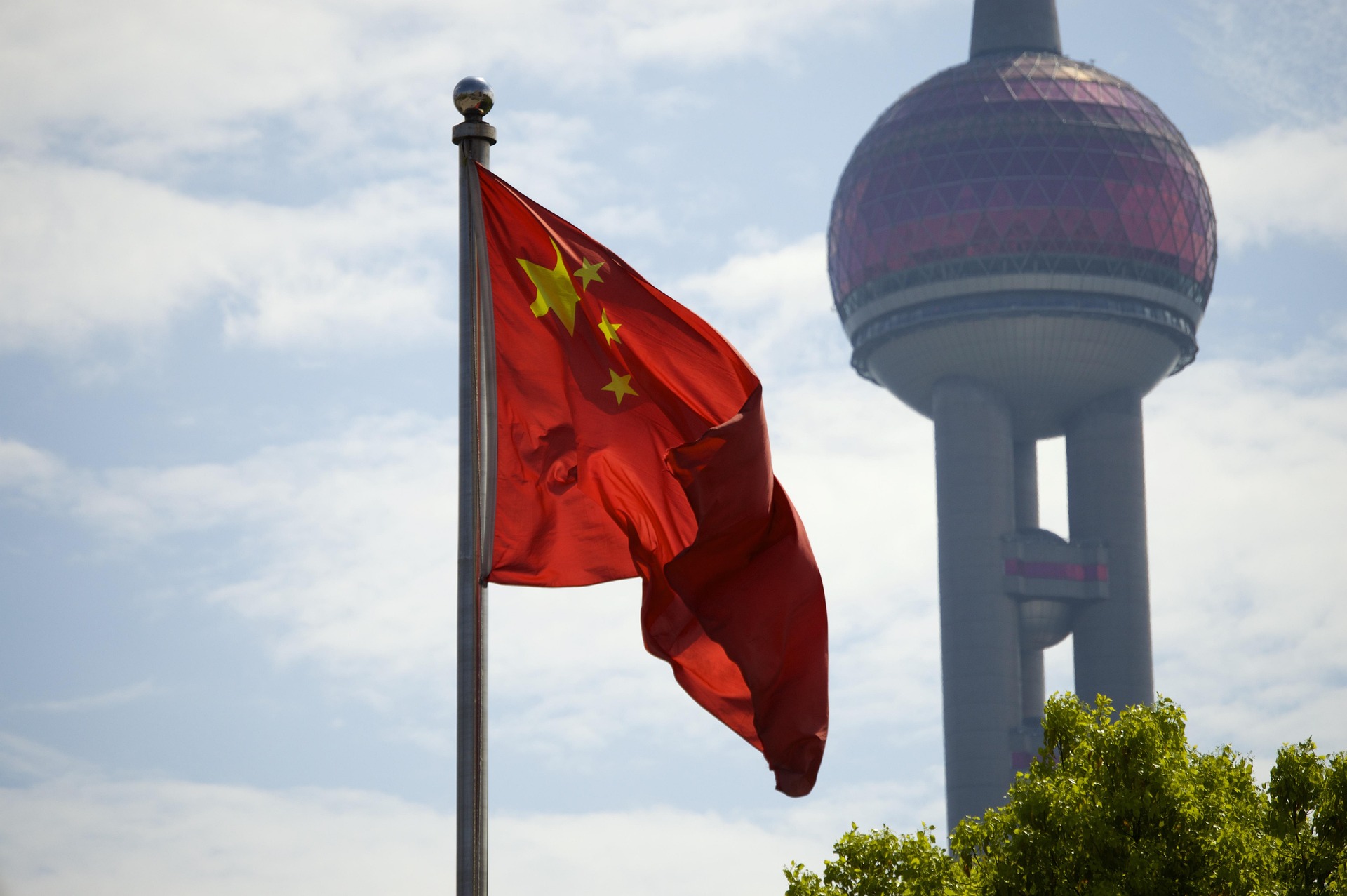 China flag on pole in front of skyscraper