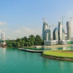 Singapore skyscrapers under construction with lake in foreground