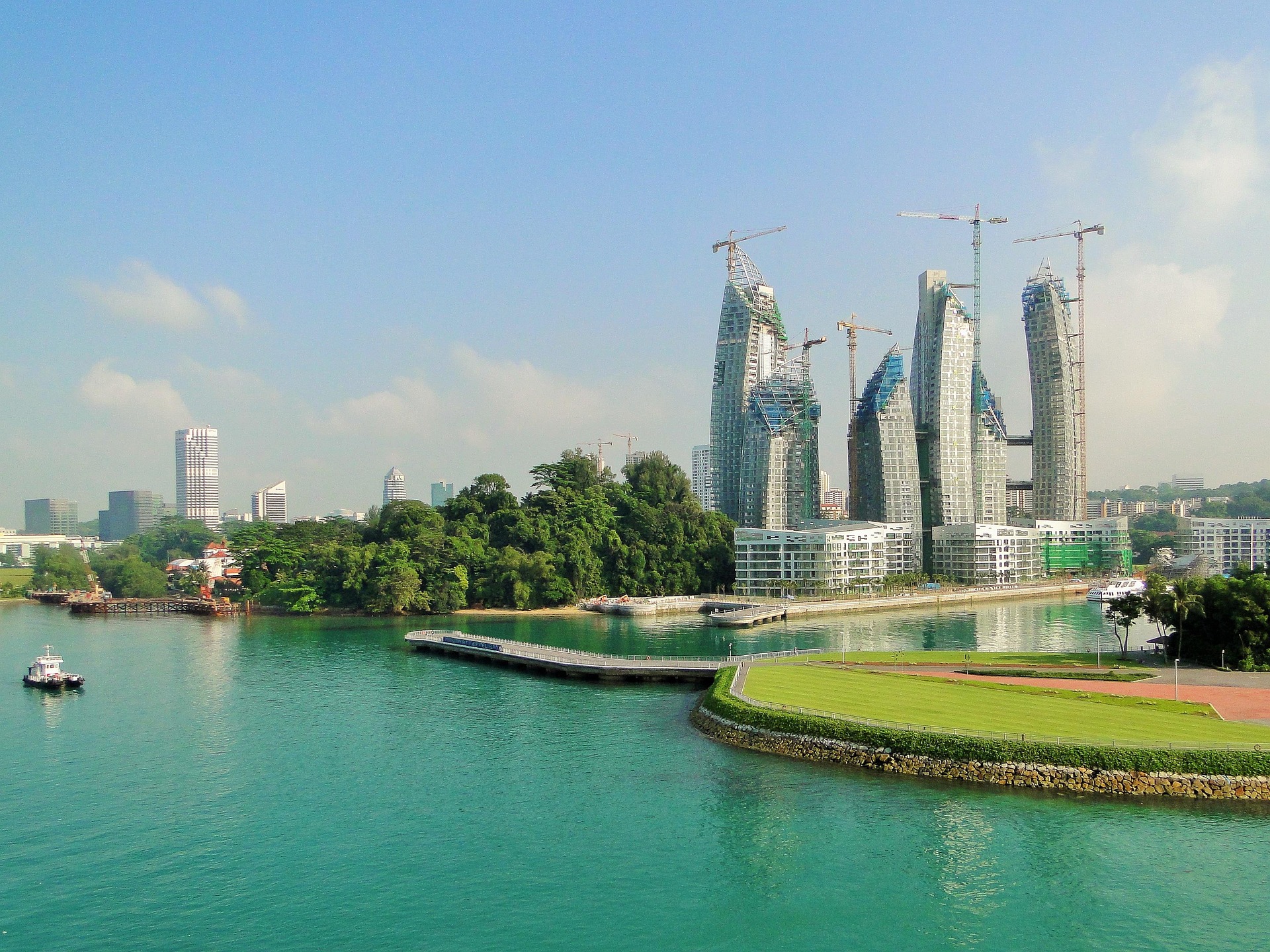 Singapore skyscrapers under construction with lake in foreground